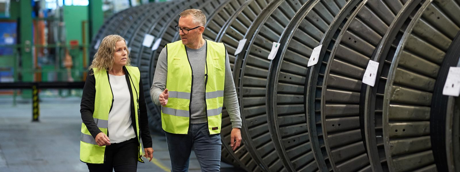 employees discussing and talking in production hall in front of cable drums